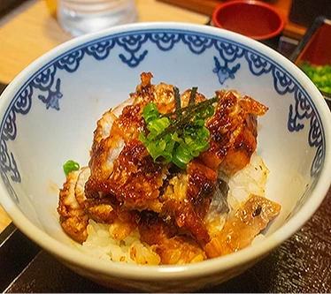 「鰻魚飯三吃」的原味炭烤鰻魚飯加入蔥花和海苔。
